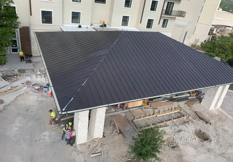 Metal roofing installation team working on a commercial building in Monitor