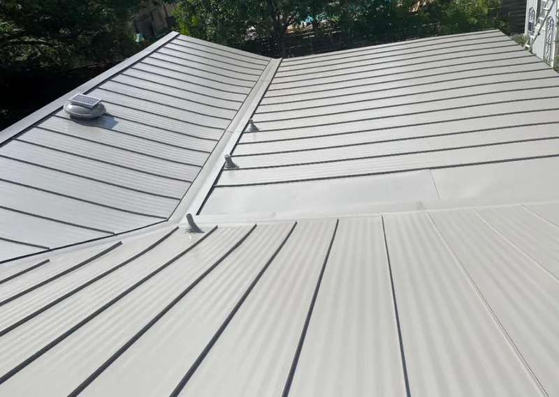 Solar attic fan installed on a metal roof for Roof Ventilation in Monitor